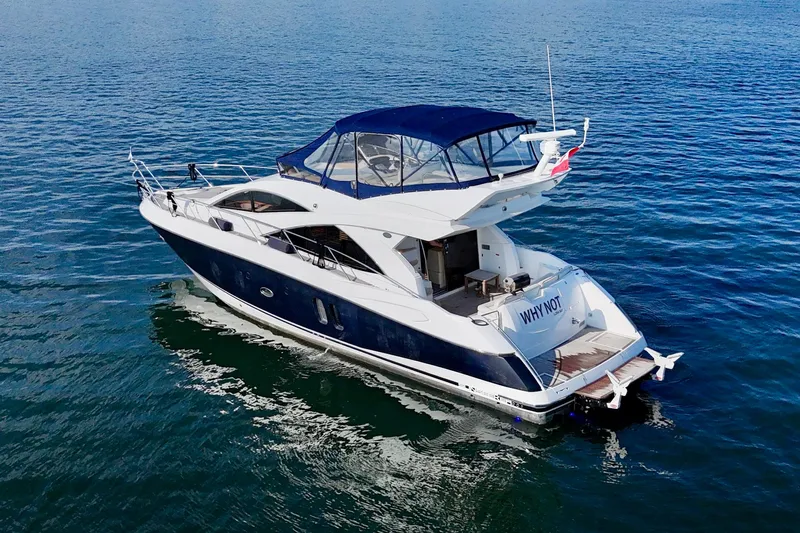 Why Not Yacht Photos Pics 2005 Sunseeker Manhattan 50 yacht on calm blue water, featuring sleek design and spacious deck.