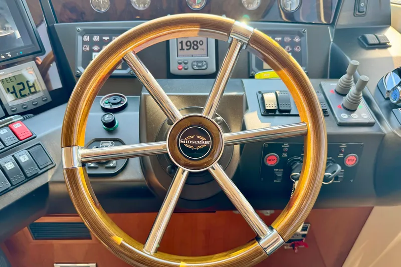 Why Not Yacht Photos Pics Steering wheel of a 2005 Sunseeker Manhattan 50 yacht, showcasing control panel.