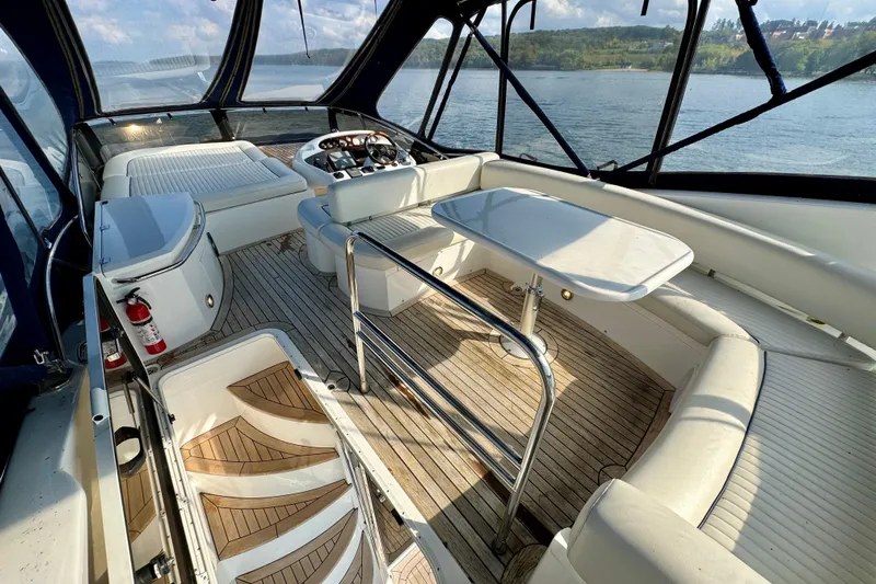 Why Not Yacht Photos Pics Luxurious 2005 Sunseeker Manhattan 50 yacht interior with seating and table, overlooking serene waters.