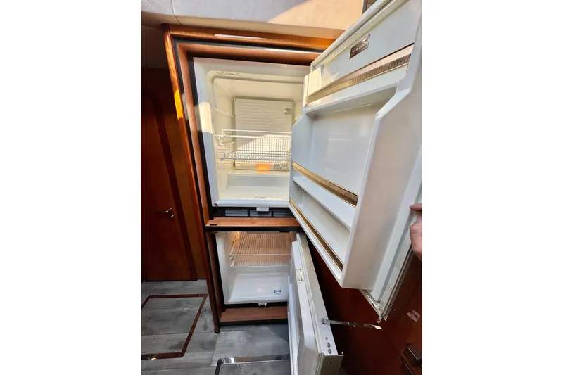 Why Not Yacht Photos Pics Open refrigerator inside 2005 Sunseeker Manhattan 50 yacht, showcasing interior storage space.