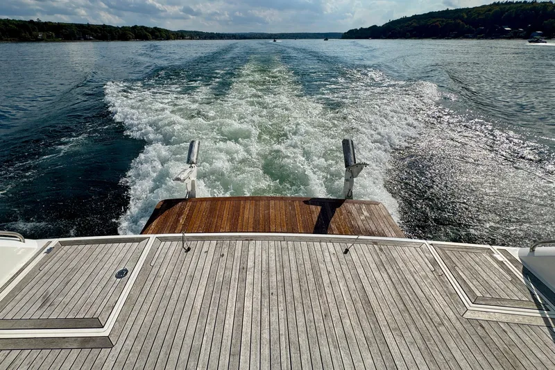 Why Not Yacht Photos Pics Rear view of 2005 Sunseeker Manhattan 50 yacht cruising on a serene lake.
