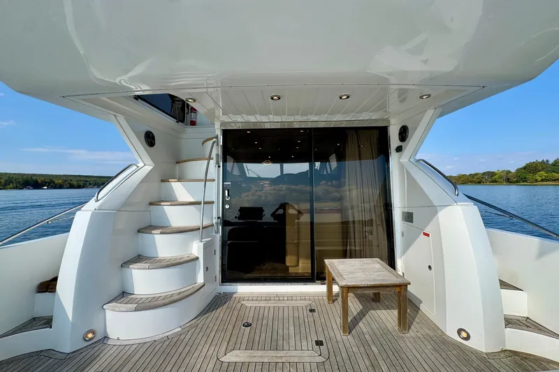 Why Not Yacht Photos Pics 2005 Sunseeker Manhattan 50 yacht deck with stairs, table, and glass doors overlooking water.