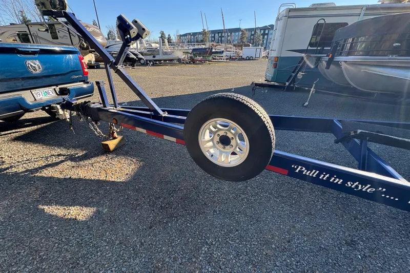  Yacht Photos Pics Blue truck towing a trailer with "Pull it in style" text, parked near RVs and boats.