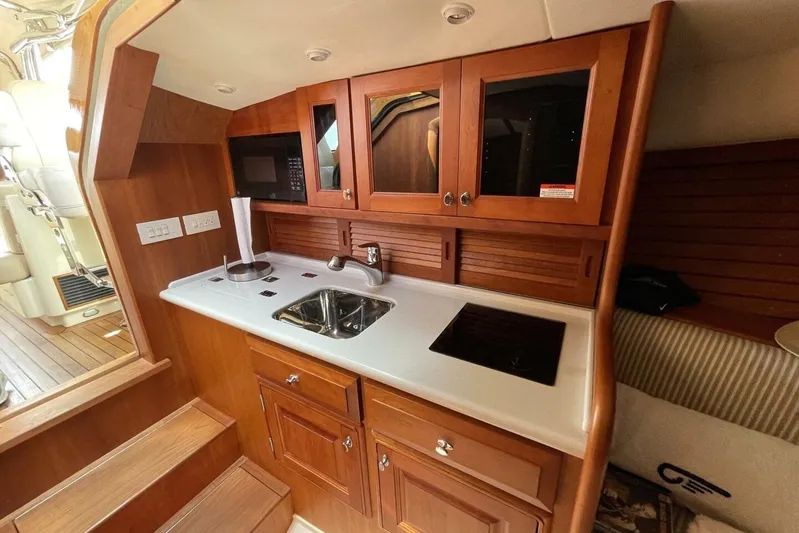Better By Far Yacht Photos Pics Interior of 2012 Hinckley Runabout 38, featuring a compact wooden kitchenette.