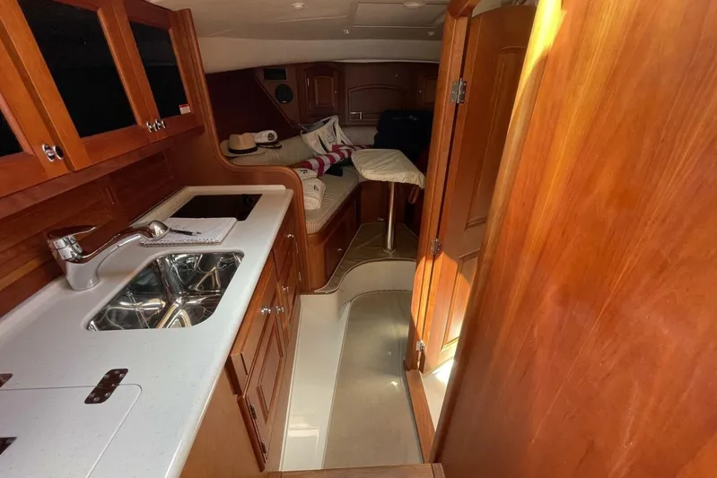 Better By Far Yacht Photos Pics Interior of 2012 Hinckley Runabout 38, featuring wooden cabinetry and compact kitchen area.