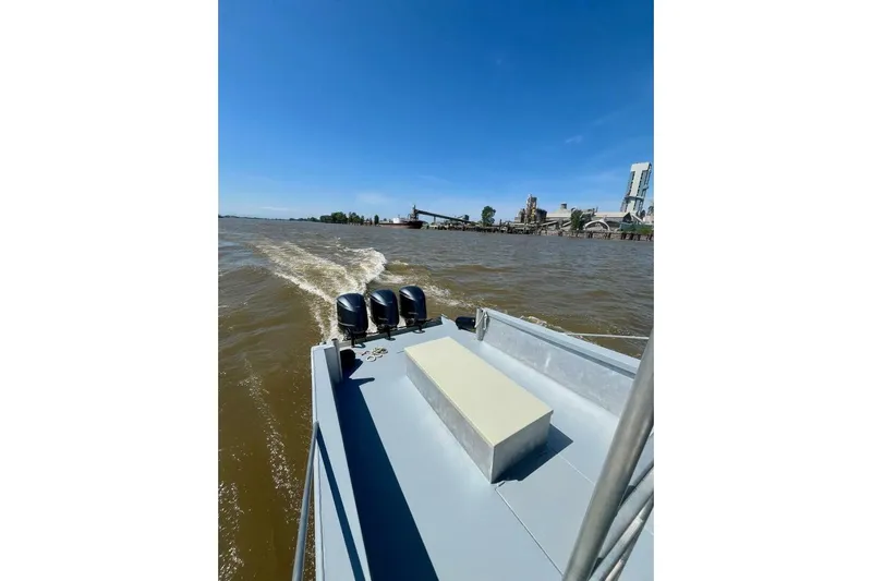  Yacht Photos Pics Custom 1990 rebuilt dive boat cruising offshore with industrial backdrop.