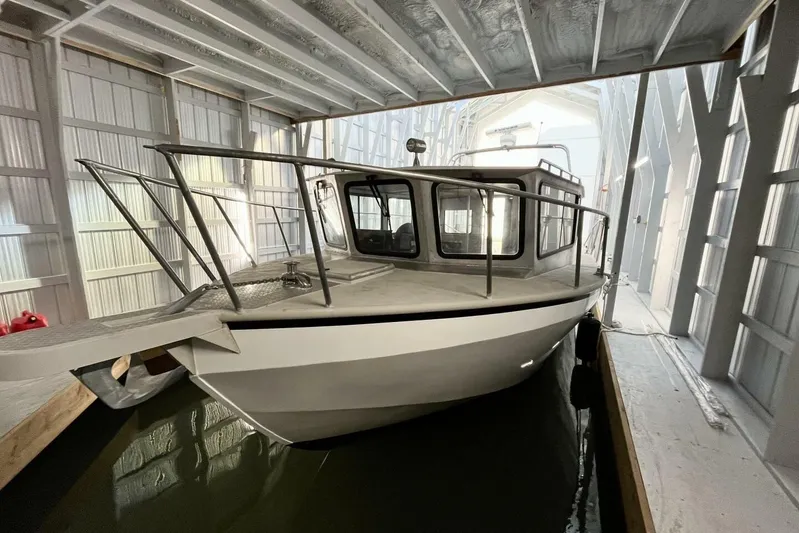  Yacht Photos Pics 1990 custom rebuilt dive boat in a covered dock, showcasing sturdy design and structure.