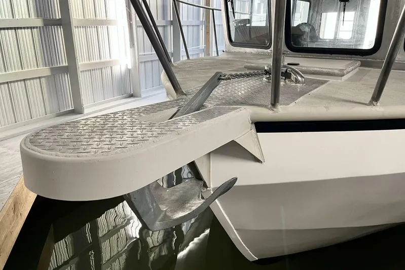  Yacht Photos Pics Custom 1990 rebuilt dive boat with anchor, docked indoors, showcasing sturdy metal deck.