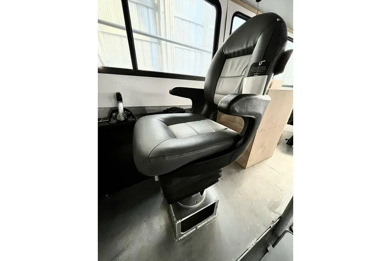  Yacht Photos Pics Captain's chair in a 1990 custom rebuilt dive boat, featuring black and gray upholstery.