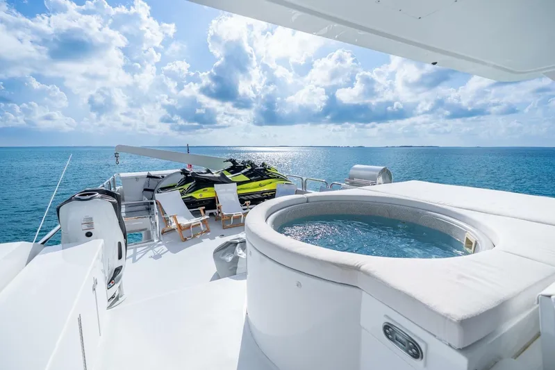 Done Deal Yacht Photos Pics Luxurious 2010 Hargrave Raised Pilothouse yacht deck with jacuzzi and jet skis on open sea.