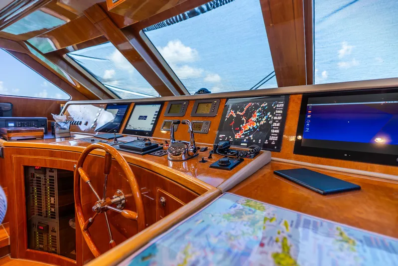 Done Deal Yacht Photos Pics Pilothouse interior of 2010 Hargrave Raised Pilothouse yacht with navigation equipment and wooden steering wheel.