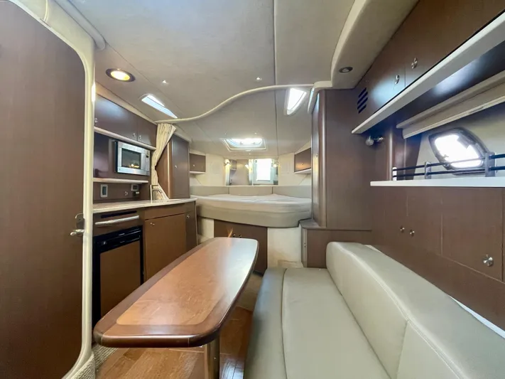 Ilaria Yacht Photos Pics 2014 Sea Ray 330 Sundancer cabin interior with kitchen, seating, and bed.