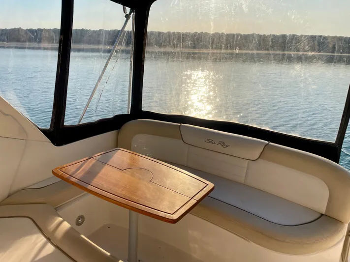 Ilaria Yacht Photos Pics 2014 Sea Ray 330 Sundancer interior with table, overlooking serene water view.