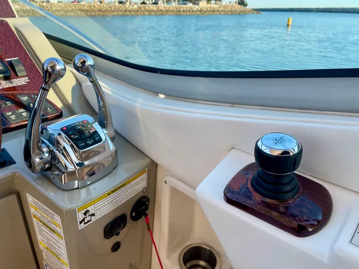 Ilaria Yacht Photos Pics Helm controls of 2014 Sea Ray 330 Sundancer with throttle and joystick, overlooking water.