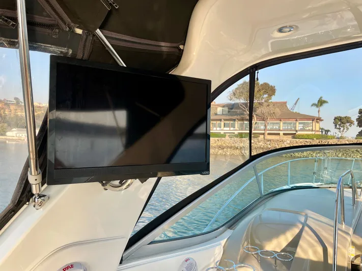Ilaria Yacht Photos Pics 2014 Sea Ray 330 Sundancer interior with mounted TV and scenic water view.