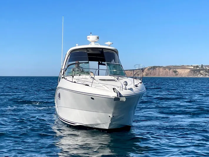 Ilaria Yacht Photos Pics 2014 Sea Ray 330 Sundancer cruising on open water with coastal cliffs in the background.