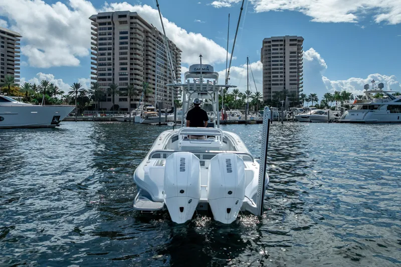  Yacht Photos Pics 2021 Yellowfin 26 Hybrid boat in marina, surrounded by tall buildings and yachts.
