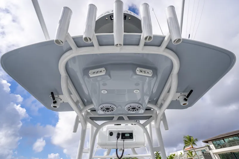  Yacht Photos Pics 2021 Yellowfin 26 Hybrid boat's T-top with rod holders and speakers against cloudy sky.
