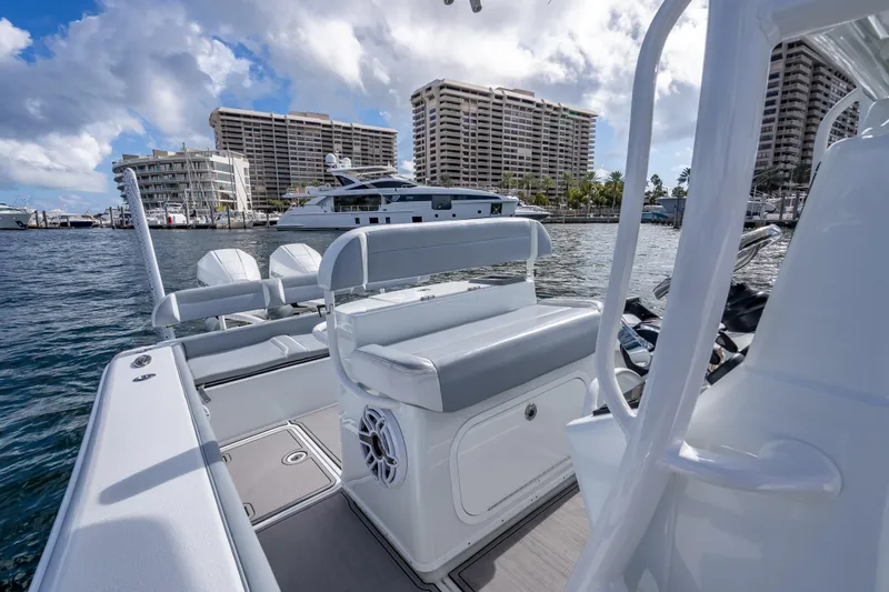  Yacht Photos Pics 2021 Yellowfin 26 Hybrid boat docked near waterfront buildings under cloudy sky.