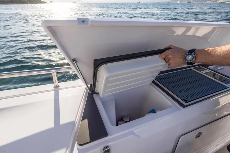  Yacht Photos Pics 2023 Axopar 45 Cross Cabine boat with open storage compartment on deck.