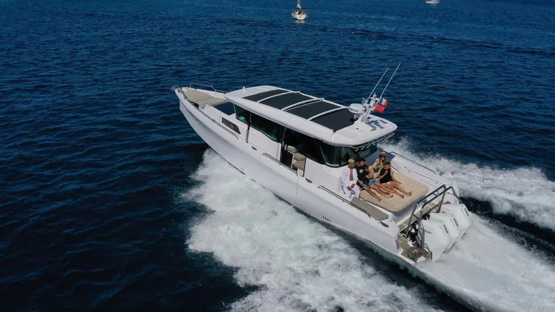  Yacht Photos Pics 2023 Axopar 45 Cross Cabin cruising on open water with passengers relaxing.