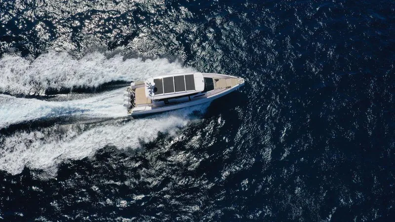  Yacht Photos Pics Aerial view of 2023 Axopar 45 Cross Cabin cruising on open water.