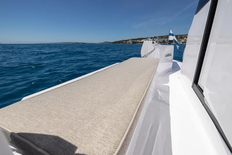  Yacht Photos Pics 2023 Axopar 45 Cross Cabine boat deck with cushioned seating, ocean view.