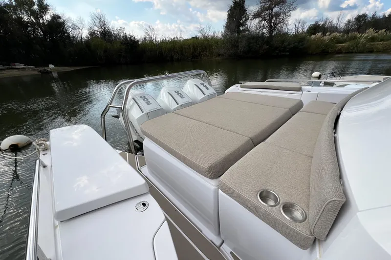  Yacht Photos Pics 2023 Axopar 45 Cross Cabine with cushioned seating and twin outboard motors on a serene river.