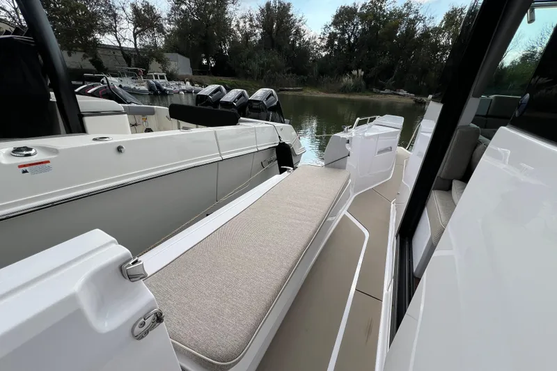  Yacht Photos Pics 2023 Axopar 45 Cross Cabine boat with cushioned seating and sleek design.