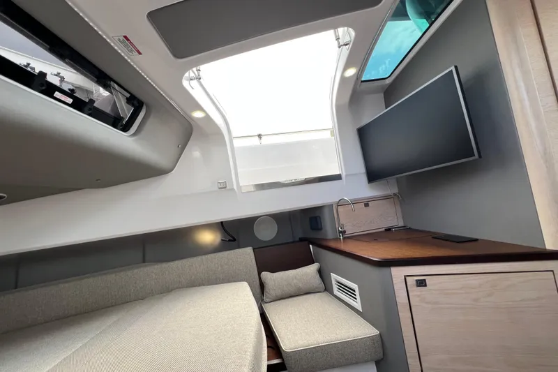  Yacht Photos Pics 2023 Axopar 45 Cross Cabine interior with modern design, featuring a sofa and TV.