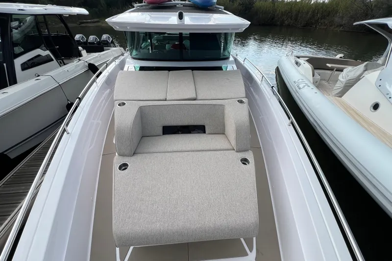  Yacht Photos Pics 2023 Axopar 45 Cross Cabin boat with cushioned seating on deck.