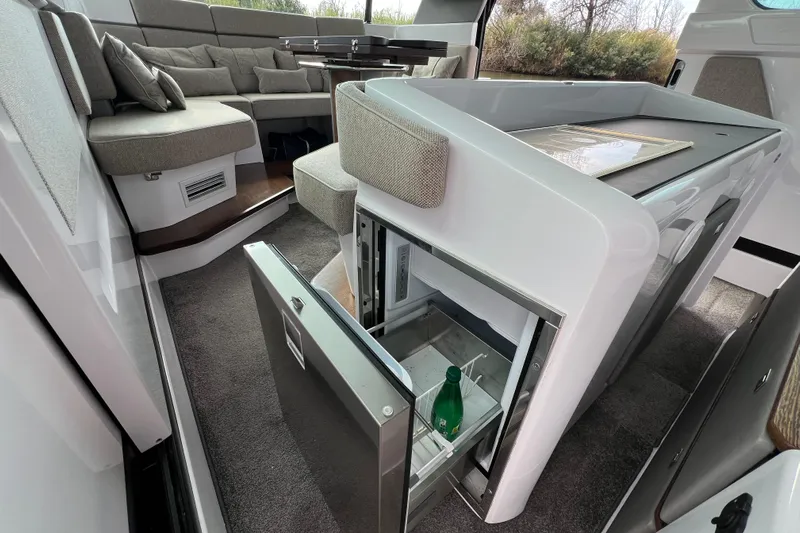  Yacht Photos Pics Luxurious interior of 2023 Axopar 45 Cross Cabin with open fridge and seating area.