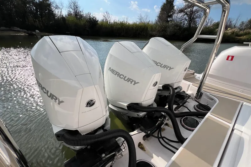  Yacht Photos Pics Triple Mercury outboard engines on 2023 Axopar 45 Cross Cabine, docked by a serene river.