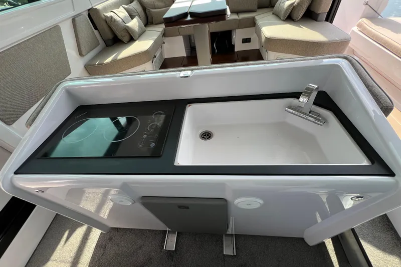  Yacht Photos Pics Modern kitchenette in 2023 Axopar 45 Cross Cabine with sink and induction cooktop.