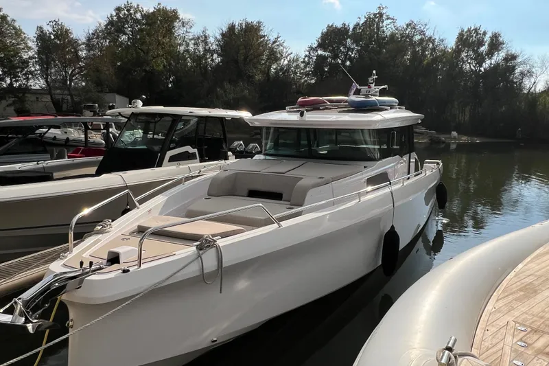  Yacht Photos Pics 2023 Axopar 45 Cross Cabin boat docked on a calm river.