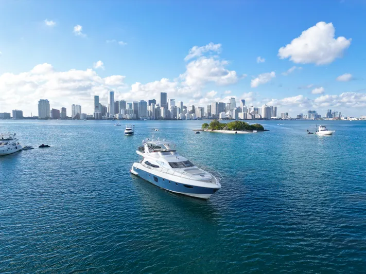 Finesse Yacht Photos Pics Luxurious 2007 Azimut 68E yacht cruising near a city skyline on a sunny day.