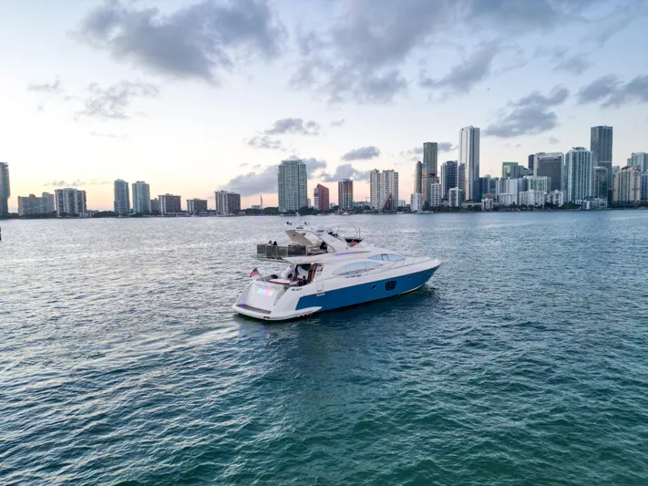 Finesse Yacht Photos Pics 2007 Azimut 68E yacht cruising near a city skyline at sunset.