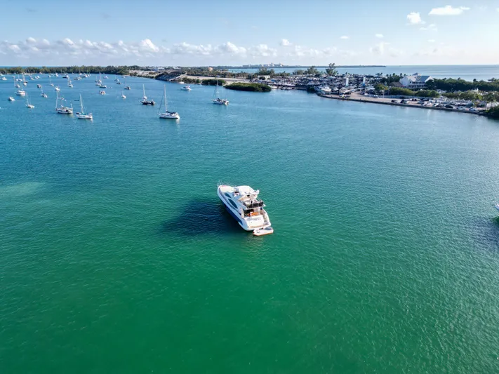 Finesse Yacht Photos Pics Azimut 68E 2007 yacht on serene turquoise waters with distant shoreline and boats.
