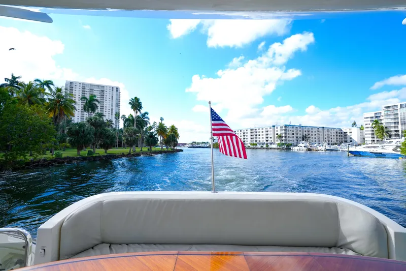 Finesse Yacht Photos Pics View from 2007 Azimut 68E yacht, American flag, waterfront cityscape, clear blue sky.