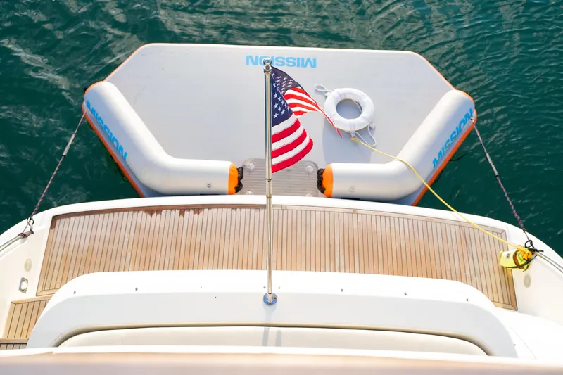 Finesse Yacht Photos Pics Azimut 68E 2007 yacht stern with American flag and inflatable platform on water.