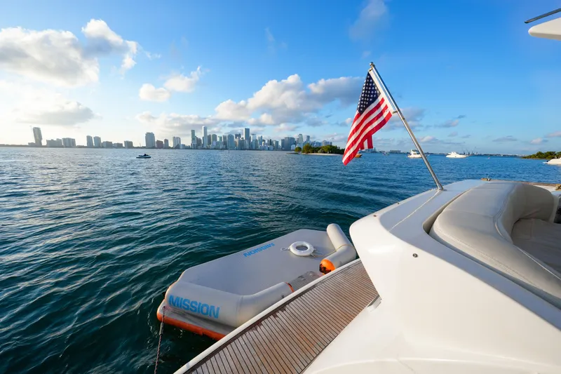 Finesse Yacht Photos Pics Azimut 68E yacht, 2007 model, with American flag, overlooking city skyline and ocean.