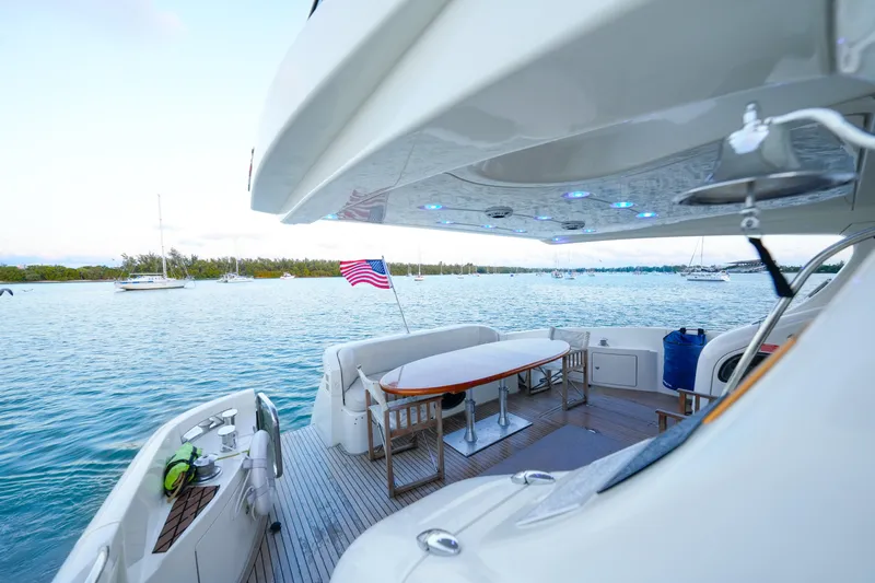 Finesse Yacht Photos Pics Luxury Azimut 68E yacht, 2007 model, with American flag, docked on serene waters.