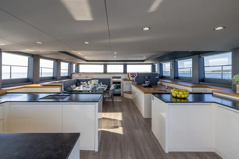  Yacht Photos Pics Modern interior of Silent 60 yacht, 2025 model, featuring spacious kitchen and dining area with ocean views.