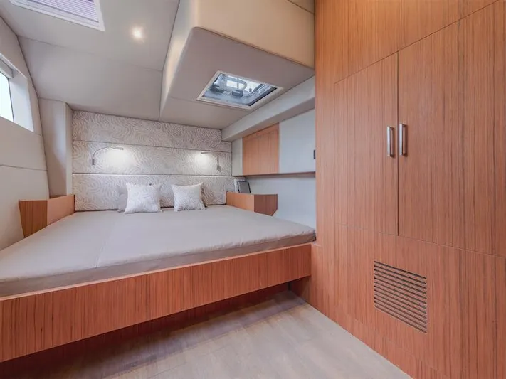  Yacht Photos Pics Modern bedroom interior of Silent 60 yacht, 2025 model, featuring wooden finishes and ample natural light.