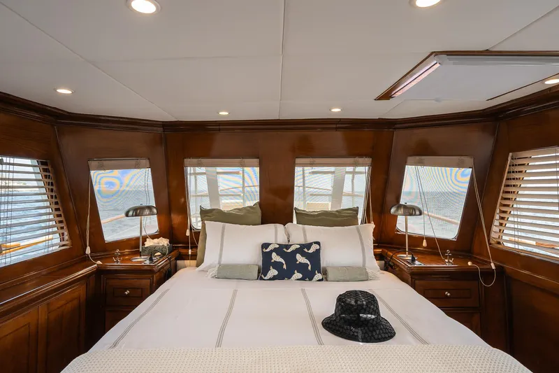 Black Pepper Yacht Photos Pics Luxurious 1975 Lavagna motoryacht bedroom with elegant wood paneling and cozy bedding.