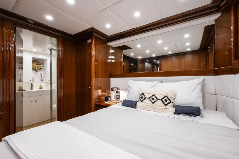 Black Pepper Yacht Photos Pics Luxurious bedroom interior of 1975 Lavagna round stern motoryacht with wood paneling and modern lighting.