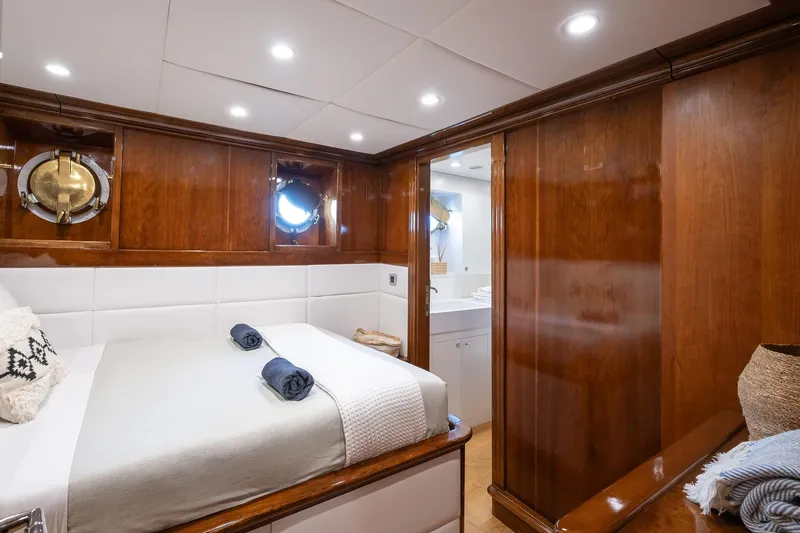 Black Pepper Yacht Photos Pics Luxurious 1975 Lavagna round stern motoryacht cabin with wood paneling and cozy bedding.