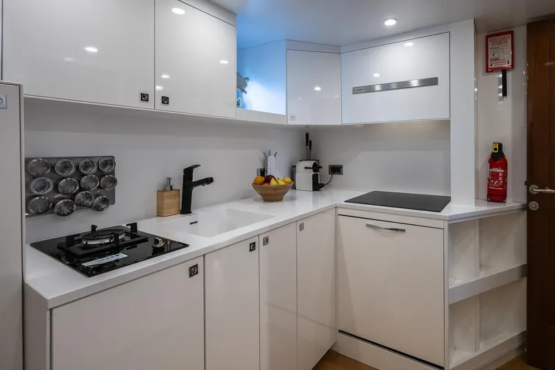 Black Pepper Yacht Photos Pics Modern yacht kitchen with sleek white cabinets, stovetop, and fruit bowl on Lavagna motoryacht, 1975.