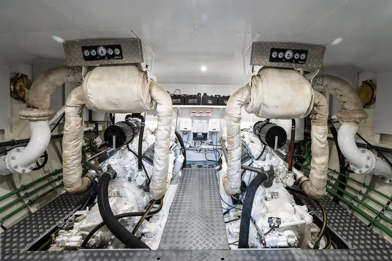 Black Pepper Yacht Photos Pics Engine room of a 1975 Lavagna round stern motoryacht, featuring dual engines and exhaust systems.