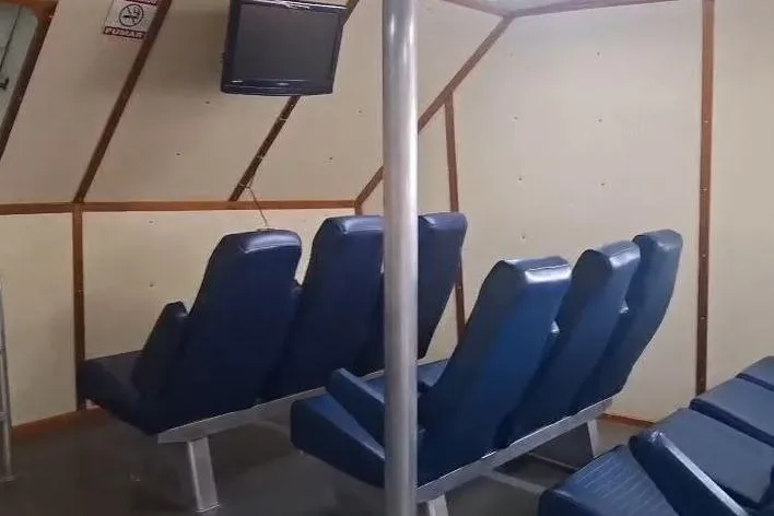  Yacht Photos Pics Interior of 2009 custom-built offshore crew vessel with blue seating and mounted TV.